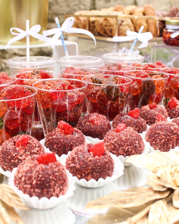 Mesa de chilitos con fresas, chamoy y dulces mexicanos en evento al aire libre
