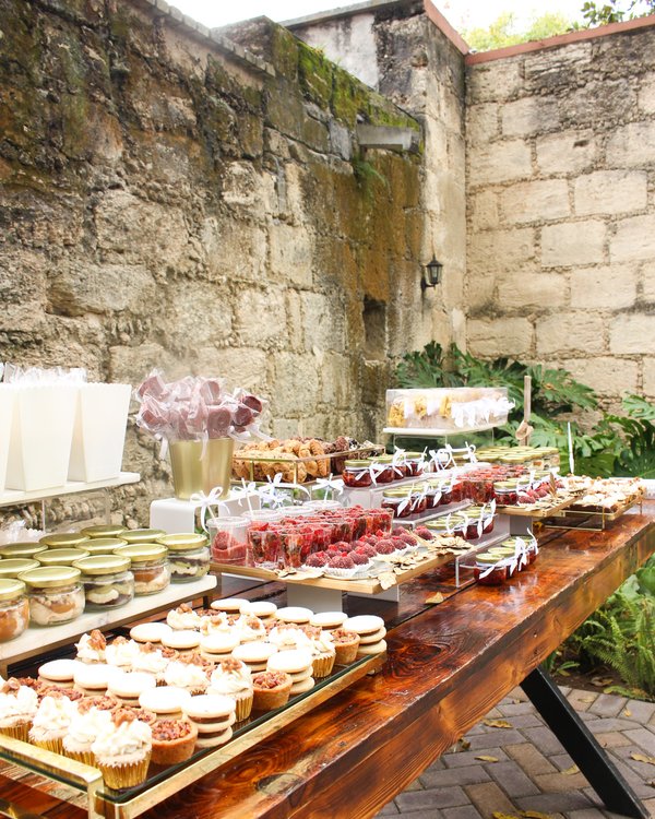 Mesa de postres con variedad amplia en patio con muro de piedra natural
